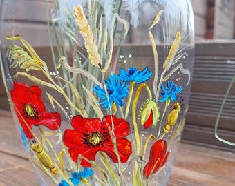 May include: A clear glass vase with a hand-painted design of red poppies, blue cornflowers, and wheat stalks. The vase is decorated with a floral motif.