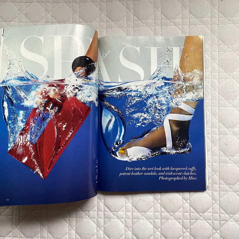 May include: A magazine spread featuring a model wearing white sandals with a blue and white background. The text on the page reads "Dive into the wet look with lacquered cuffs, patent-leather sandals, and iridescent clutches. Photographed by Hiro."