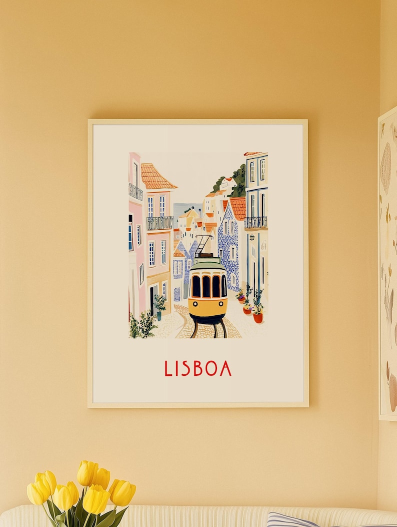 May include: A colorful illustration of a yellow tram traveling through a narrow street in Lisbon, Portugal. The buildings are painted in shades of pink, blue, and white. The text "LISBOA" is printed in red at the bottom of the image.