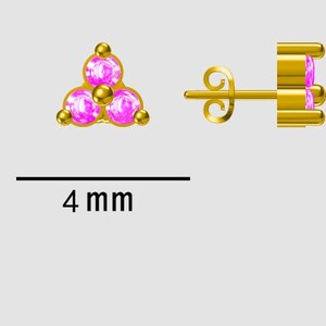 May include: Gold-colored stud earrings with a cluster of three pink gemstones, each surrounded by a gold bead. The earrings are 4 mm in size. One earring is shown from the front, and the other from the side.