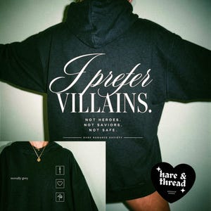 May include: Black hoodie with the text "I Prefer Villains" in white script. The hoodie also features the text "Not Heroes. Not Saviors. Not Safe." and the brand name "hare & thread". A smaller image shows a dark grey hoodie with the text "morally grey".