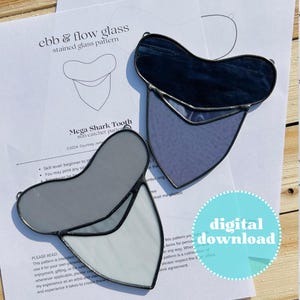 May include: A digital download pattern for a stained glass suncatcher shaped like a shark tooth. The pattern is titled "Mega Shark Tooth Suncatcher Pattern" and includes instructions for creating the project. The pattern is available for download and is suitable for beginners.