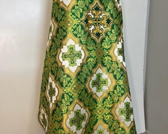 Könnte beinhalten: Ein grünes und goldenes liturgisches Gewand mit einem Kreuzmuster. Das Gewand ist aus Brokatstoff mit einem Blumendesign.