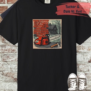 Pode incluir: Camiseta preta com um gráfico do filme "Tucker & Dale Vs. Evil". O gráfico inclui uma motosserra, um machado e texto. A camisa é combinada com jeans e tênis.