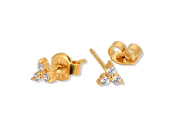 May include: Gold-coloured stud earrings, each featuring a cluster of three clear gemstones. The earrings have a post and butterfly backing. The design is simple and elegant, suitable for everyday wear or special occasions.