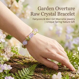 May include: A macrame bracelet with raw crystals and floral accents. The bracelet features light purple and clear crystals, with small green and yellow floral details. The text "Garden Overture Raw Crystal Bracelet" is displayed above the bracelet.