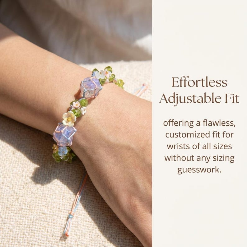 May include: A delicate bracelet featuring light blue and clear crystal beads, interspersed with small white and green floral accents. The bracelet is shown on a wrist, with the text "Effortless Adjustable Fit".