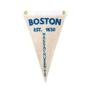 Pode incluir: Um estandarte triangular branco com texto bordado em azul que diz "BOSTON EST. 1630 MASSACHUSETTS".