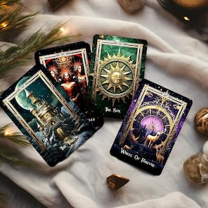 Pode incluir: Quatro cartas de tarot com designs ornamentados e detalhes dourados. As cartas apresentam imagens de uma torre, tr&ecirc;s figuras, um sol e veados. O texto nas cartas diz "The Tower", "The Sun", "Wheel Of Fortune" e "LES".