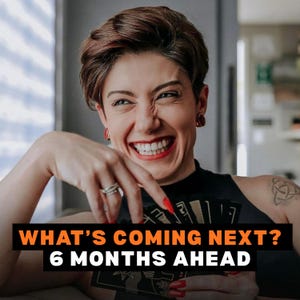 May include: A woman smiling, holding tarot cards. The image has the text "WHAT'S COMING NEXT? 6 MONTHS AHEAD" in orange and white. The woman has short brown hair, red earrings, and red nail polish.