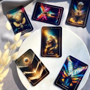Pode incluir: Um conjunto de cartas de tarot com ilustra&ccedil;&otilde;es vibrantes. As cartas exibem imagens de anjos, borboletas e corpos celestes, com t&iacute;tulos como "Temperan&ccedil;a", "Amantes" e "For&ccedil;a". As cartas est&atilde;o dispostas sobre uma superf&iacute;cie branca.