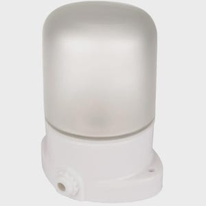 Puede incluir: Una luminaria exterior cilíndrica blanca con una cúpula de vidrio esmerilado. La base es blanca con una pequeña abertura circular y un orificio de montaje. Diseñada para uso en exteriores.