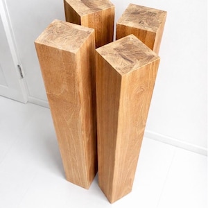 Puede incluir: Cuatro bloques de madera sin terminar con veta natural. Los bloques son rectangulares y se estrechan ligeramente de arriba a abajo. La madera es de color marrón claro y tiene un patrón de veta visible.