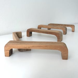 Minimalistische Griffe aus hellem Teakholz