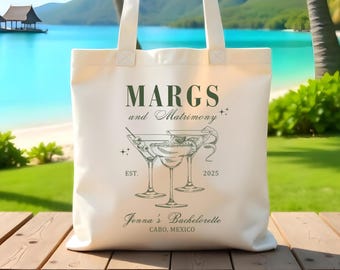 Peut inclure: Sac fourre-tout en toile blanche avec un motif graphique vert représentant trois verres de margarita et le texte "MARGS and Matrimony EST. 2025 Jenna's Bachelorette CABO, MEXICO".