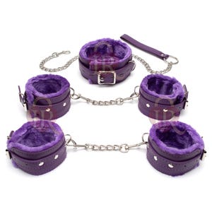 Puede incluir: Un conjunto de restricciones de cuero púrpura con interiores de felpa púrpura suave. El conjunto incluye un par de esposas, un par de tobilleras y una restricción para el cuello, todas conectadas por cadenas plateadas. También se incluye un asa de cuero púrpura a juego.