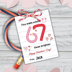 Può includere: Un biglietto di San Valentino con un design a matita. Il biglietto presenta il numero 67 formato da matite, il testo "You make school times brighter" e "Happy Valentine's Day!". È legato con uno spago rosso e bianco.