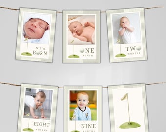 May include: A set of six rectangular photo cards hanging on a string, featuring a golf theme with striped borders. Each card displays a baby photo or a golf hole illustration with text labels including New Born, One Month, Two, Eight, and Nine Months.