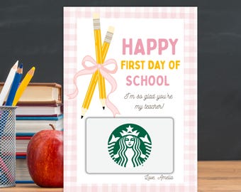 May include: A rectangular card with a light pink gingham border featuring two yellow pencils tied with a pink ribbon. The text reads HAPPY FIRST DAY OF SCHOOL, I'm so glad you're my teacher!, and Love, Amelia. A Starbucks gift card is attached to the center.