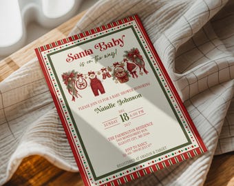 May include: A rectangular baby shower invitation card with a cream background, red and green striped borders, and festive illustrations of baby clothes on a clothesline. The text reads Santa Baby is on the way, Natalie Johnson, Dec 18, 2027.