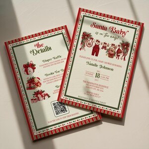 May include: Two rectangular baby shower invitation cards with a red and green border. The text reads Santa Baby is on the way, Natalie Johnson, Dec 18, 2027, and The Details. Illustrations include baby clothes, a teddy bear, and a QR code.
