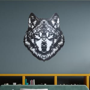 May include: A black and white wolf head silhouette wall decor in a living room setting with a green sofa, yellow shelves, and books.