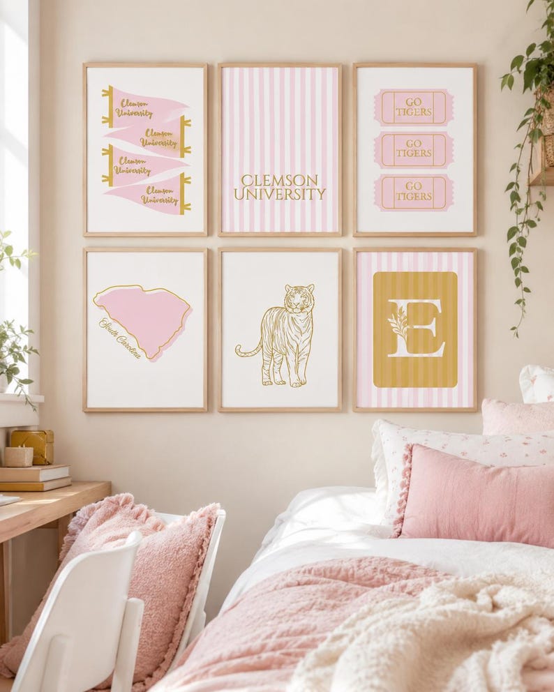 May include: A set of six framed wall art prints featuring Clemson University themes in pink, white, and gold. Designs include pennants, striped patterns, ticket stubs with Go Tigers text, a South Carolina map, a tiger illustration, and a letter E.