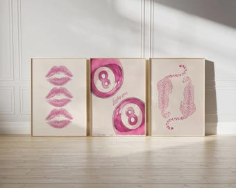Puede incluir: Tres impresiones artísticas enmarcadas. La impresión de la izquierda presenta tres huellas de labios rosas. La impresión central muestra dos ilustraciones de bolas ocho rosas con el texto "Lucky you". La impresión de la derecha muestra dos ilustraciones de guepardos rosas.