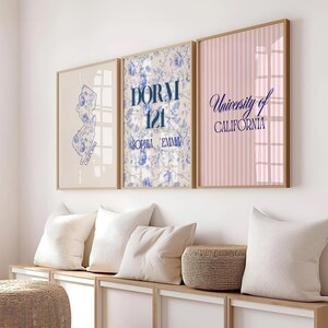 Pode incluir: Tr&ecirc;s obras de arte emolduradas. A primeira apresenta um mapa azul da Calif&oacute;rnia. A segunda tem texto azul que diz "DORM 121 SOPHIA EMMA" em um fundo floral. A terceira tem listras rosa e o texto "University of CALIFORNIA".
