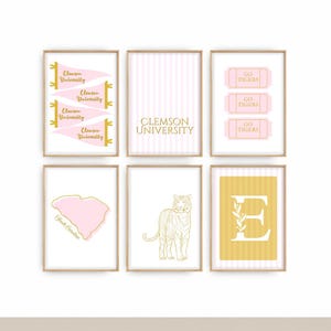 May include: A set of six framed wall art prints featuring Clemson University themes in pink, gold, and white. Designs include pennants, the text Clemson University, Go Tigers tickets, a South Carolina map, a tiger illustration, and the letter E.