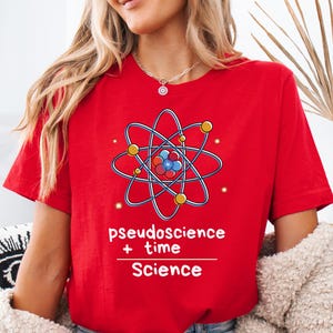 May include: Red t-shirt with a white atom graphic and the text "pseudoscience + time = Science".