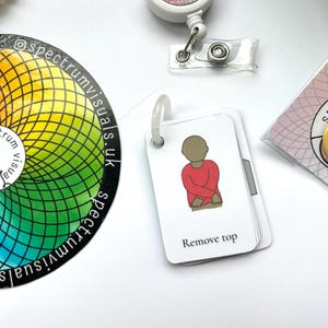 May include: A white card with a cartoon illustration of a person wearing a red shirt. The text "Remove top" is printed below the illustration.