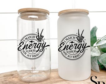 May include: Two glass drinking cups with bamboo lids and clear straws. One cup is clear, the other is frosted. Both cups have a black graphic that reads "I match energy, so how we gon' act today?"
