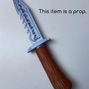 May include: 3D printed prop knife with a silver blade and a brown handle. The blade has a serrated edge and etched detailing. The text "This item is a prop" is visible.