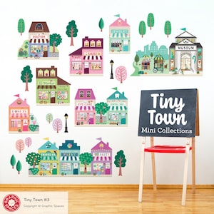 May include: A wall decal set featuring a colorful illustration of a miniature town with various shops, trees, and a museum. The set includes a chalkboard easel with the text "Tiny Town Mini Collections".