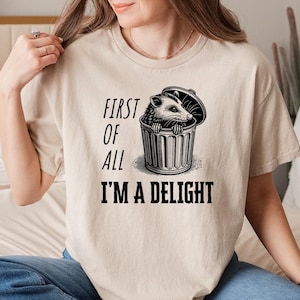 First of All I&#39;m a Delight T-Shirt | Funny Opossum Shirt | Possum Trash Can Graphic Tee | Sarcastic Saying Shirt | Quirky Gift Idea