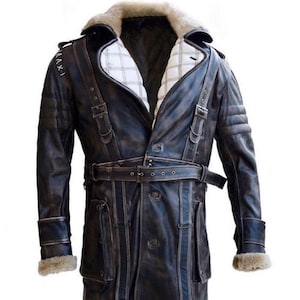 Può includere: Un lungo cappotto di pelle marrone scuro con colletto di pelliccia e cintura. Il cappotto ha una chiusura a doppio petto e diverse tasche.