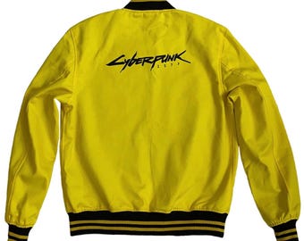 May include: A yellow bomber jacket with black and yellow striped ribbing at the collar, cuffs, and hem. The back of the jacket features a black graphic of the text "Cyberpunk 2077".