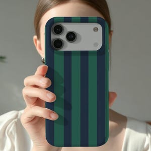 May include: A navy blue and green striped phone case. The case has a dark blue border and a vertical stripe pattern in alternating shades of green and navy blue. The phone case is designed to fit a smartphone.