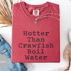 Camiseta "Más caliente que el agua hirviendo de cangrejos", humor sureño, camiseta para amantes de los cangrejos, camiseta de Luisiana, colores cómodos, mariscada, divertida camiseta de cangrejos