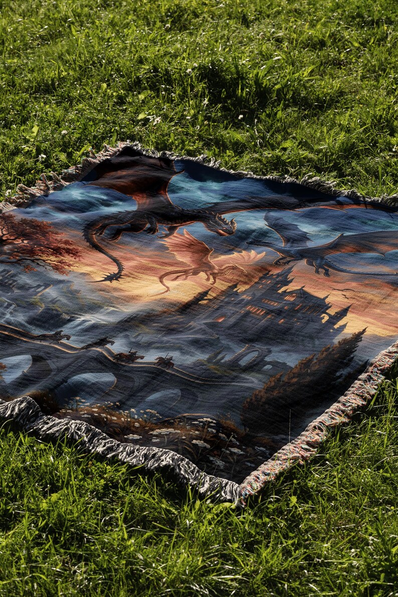 Pu&ograve; includere: Una coperta rettangolare con una scena fantasy. L'opera d'arte raffigura draghi, un castello e un ponte. I draghi volano contro un cielo al tramonto, con un castello e un ponte in primo piano. La coperta ha un bordo con frange.
