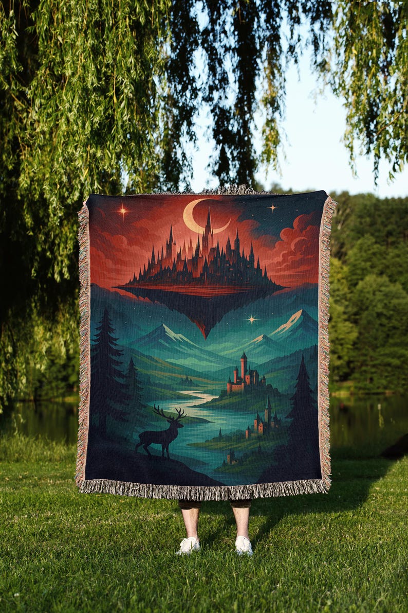 Peut inclure: Une couverture en tapisserie tiss&eacute;e repr&eacute;sentant un paysage fantastique avec un ch&acirc;teau, des montagnes et un cerf. La palette de couleurs comprend des nuances de rouge, de bleu et de vert. La couverture a une bordure &agrave; franges.