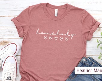 Camiseta Cursiva Homebody | Camiseta Gráfica Aconchegante com Corações | Perfeita para Relaxar | Camiseta Macia e Confortável | Presente para Amantes do Lar