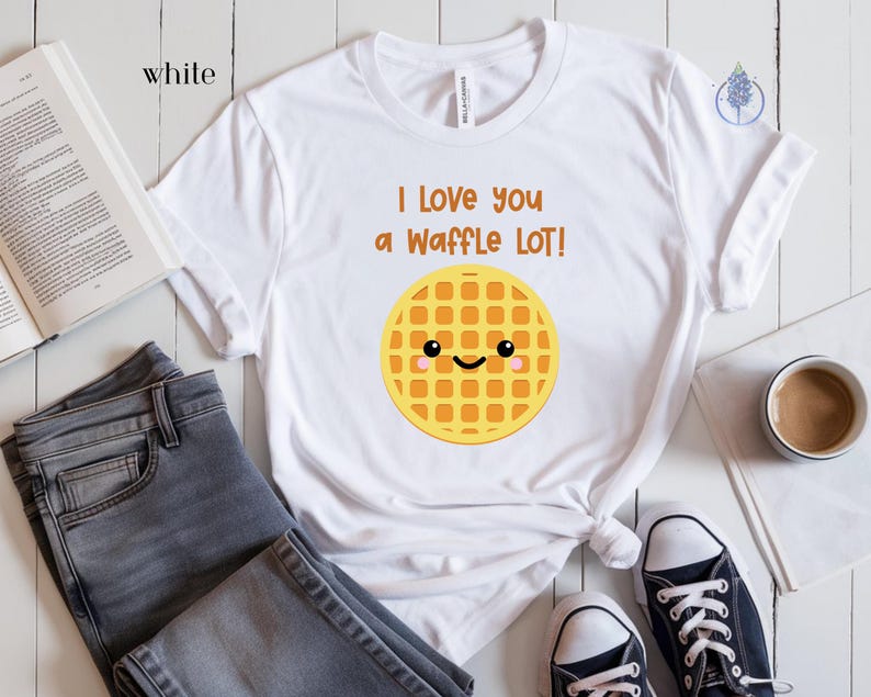 May include: White t-shirt with a cute cartoon waffle with a smiling face and the text "I love you a waffle lot!"