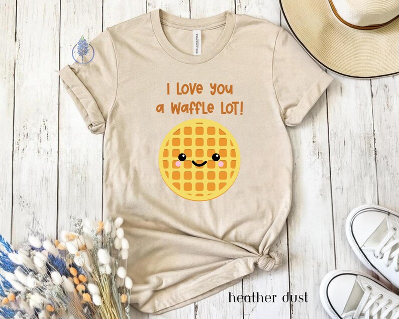 May include: A beige t-shirt with the text "I love you a waffle lot!" and a cartoon waffle with a smiling face.