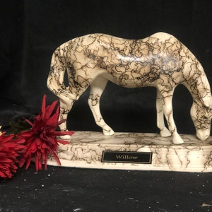 May include: White ceramic horse figurine with black swirling patterns, standing on a base with the word "Willow" inscribed on a plaque.