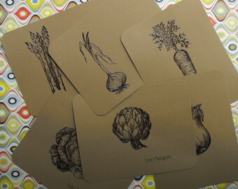 May include: Set of eight brown kraft paper cards with black ink illustrations of various vegetables. The cards feature asparagus, onions, artichokes, carrots, and eggplant. Each card has the text "Lori Reagan" printed on the bottom.