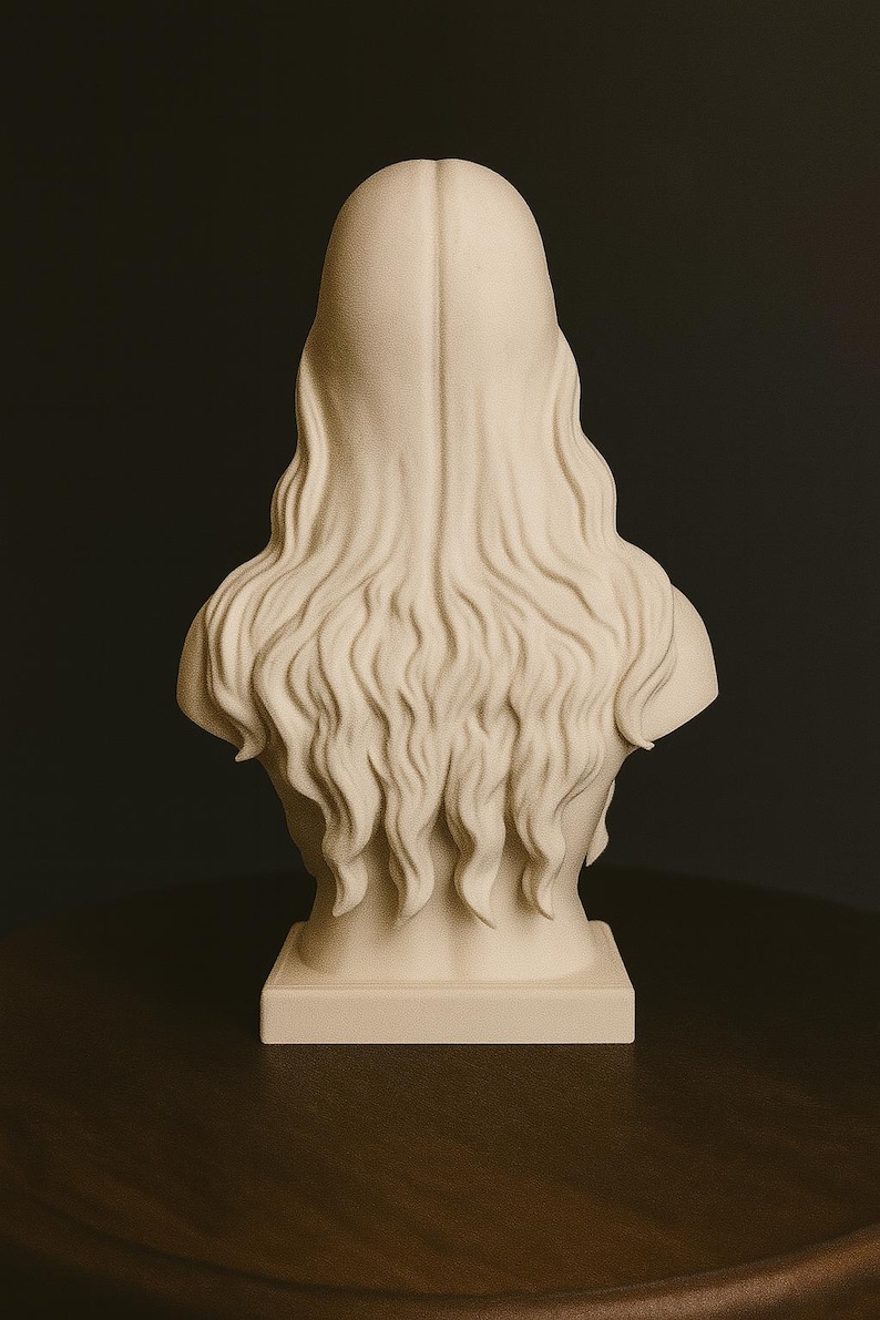 May include: A cream-colored bust sculpture depicting a person with long, flowing hair. The sculpture is set on a rectangular base and is viewed from the back. The hair cascades down the back in wavy strands.