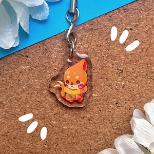 May include: A clear acrylic keychain featuring a cartoon fox wearing an orange life preserver. The fox is orange and white with a pink nose and brown eyes. The keychain is attached to a silver metal chain.