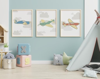 May include: Three framed prints of airplanes with clouds in the background. The airplanes are blue, green, and red. The prints are hanging on a light blue wall. There is a teepee tent in the foreground.